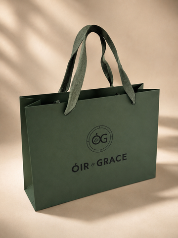 Óir & Grace luxury recycled gift bag in heritage green with woven handles and black logo.